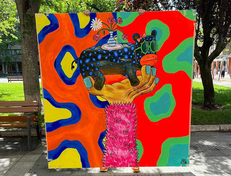 un estudiante universitario sostiene un cuadro pintado para una empresa de servicios de alojamiento para estudiantes en Pamplona