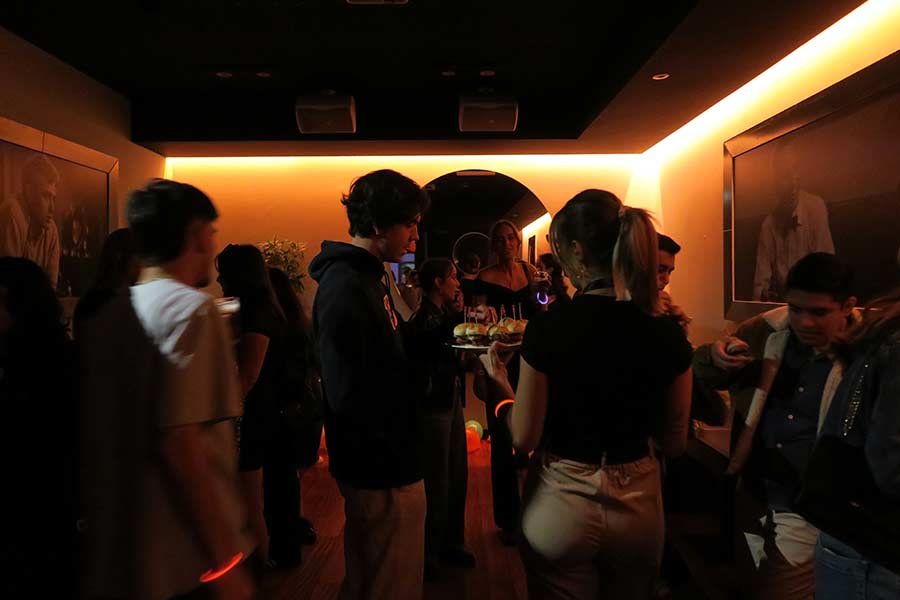 en un bar una camarera trae hamburguesas en una bandeja para los estudiantes universitarios que celebran una fiesta de bienvenida