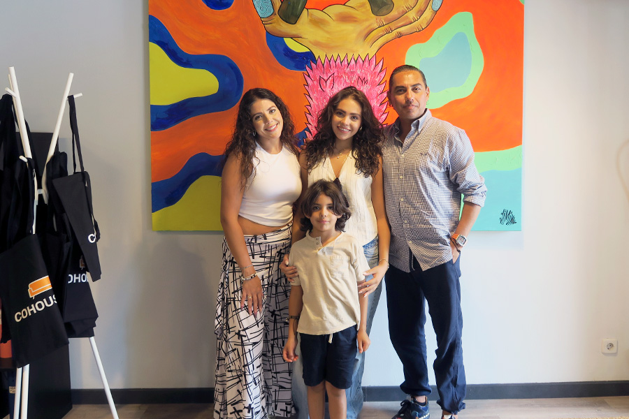 una estudiante colombiana con su padre, su madre y su hermano. Sonríen en el local de Cohousing en Pamplona