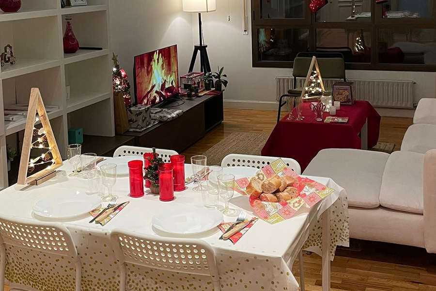 apartamento decorado de Navidad con la mesa preparada para tener una cena para los estudiantes