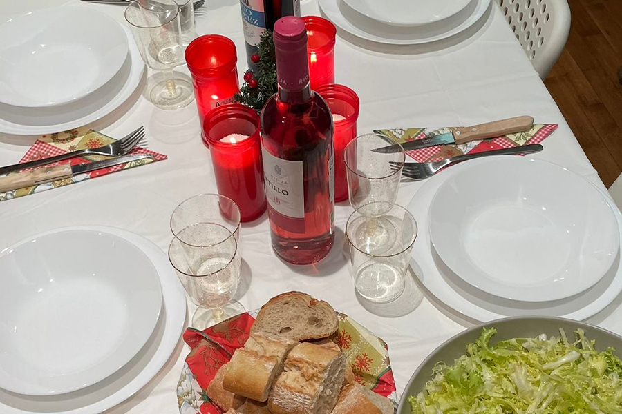 detalle de una mesa navideña con vino, velas y la vajilla en un piso de estudiantes de Pamplona